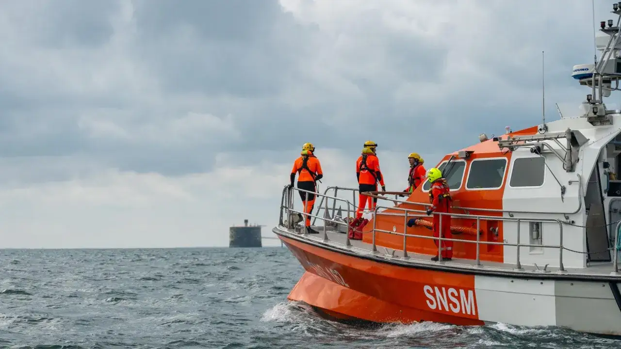 Équipage de la SNSM en tenue orange sur un bateau, prêt à intervenir suite à un bateau accident.