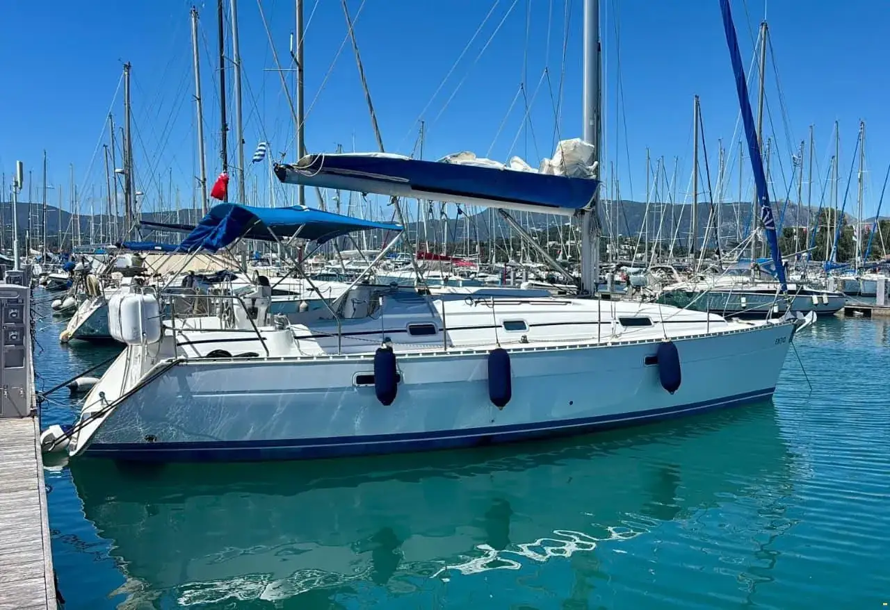 Un voilier Oceanis 331, blanc avec une ligne bleue, est amarré dans un port. Les avis sur ce modèle sont positifs.