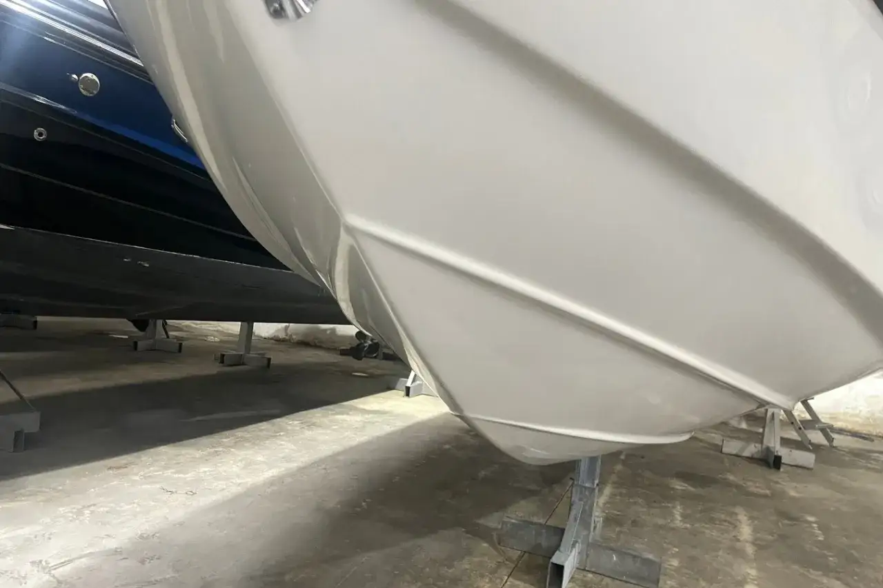 La coque blanche d'un bateau, prête à fendre les flots. Sa forme suggère une grande vitesse d'un bateau.