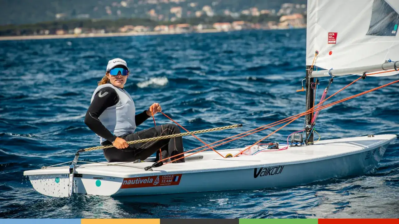 Louise Cervera, navigatrice française, manœuvre son dériveur ILCA sur une mer bleue. Elle porte une casquette et des lunettes de soleil.