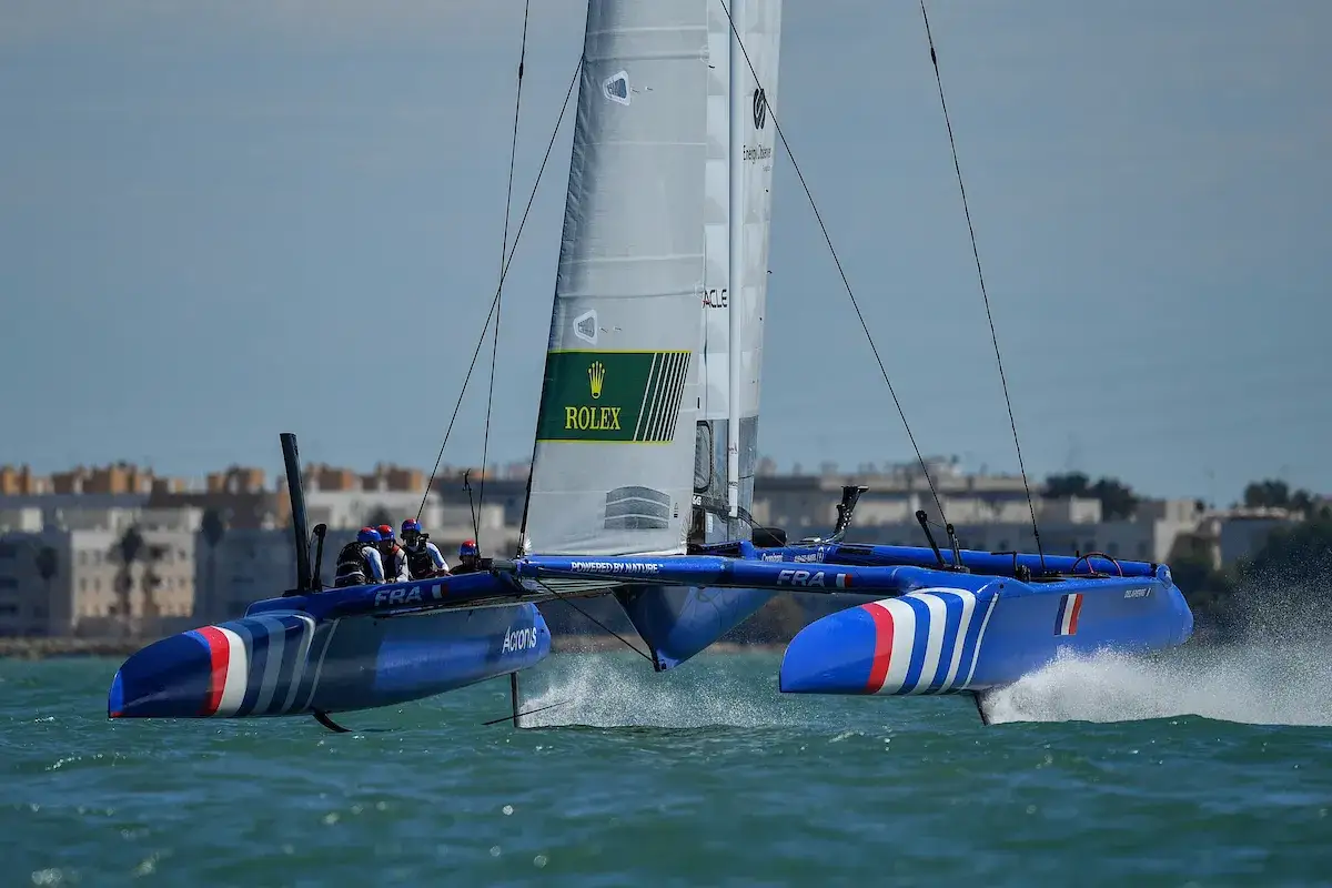 Le catamaran bleu de Quentin Delapierre fend les vagues, sponsorisé par Rolex.