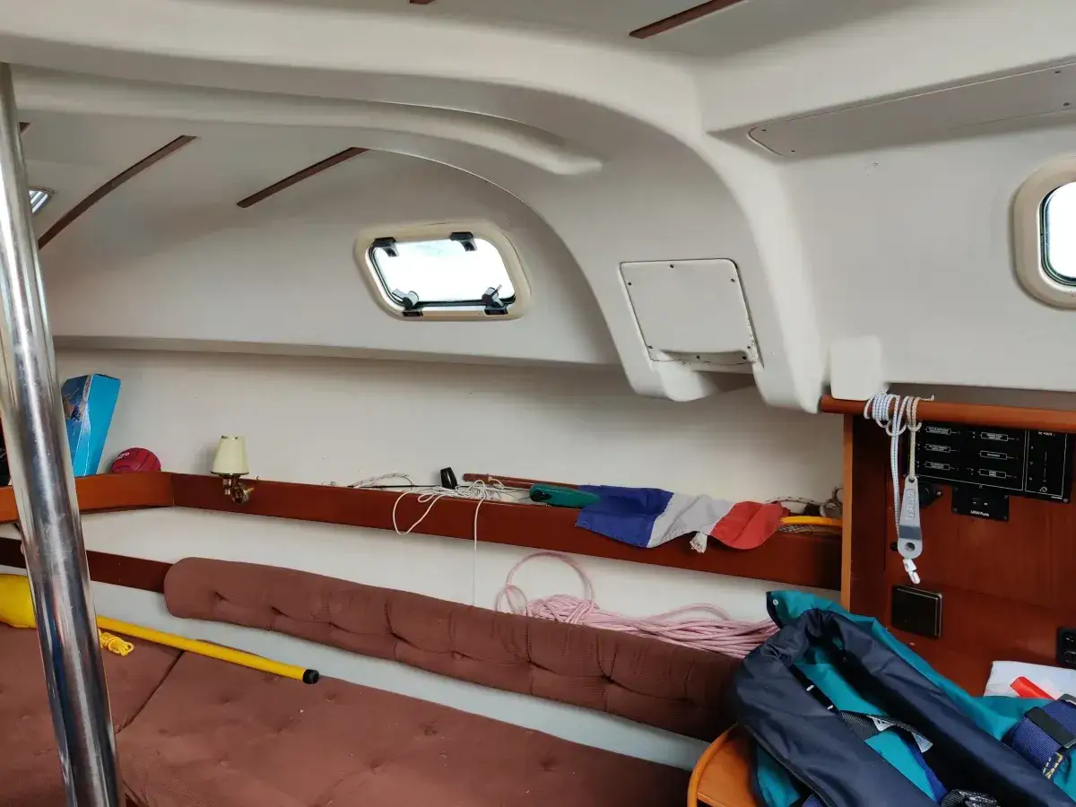Intérieur d'un voilier avec banquette, hublots, cordages et un gilet de sauvetage. Les premiers 265 avis sont positifs.
