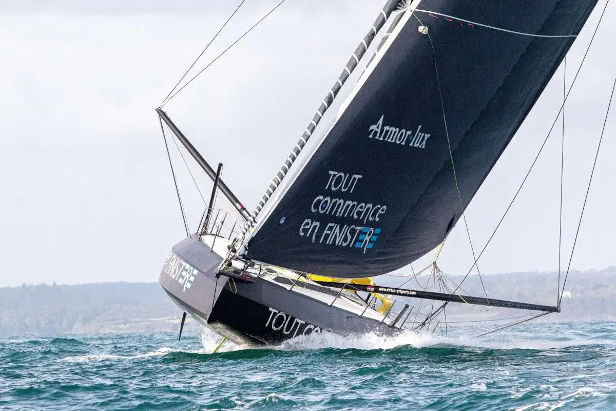 Le voilier IMOCA de Jean Le Cam fend les vagues, sa grand-voile noire