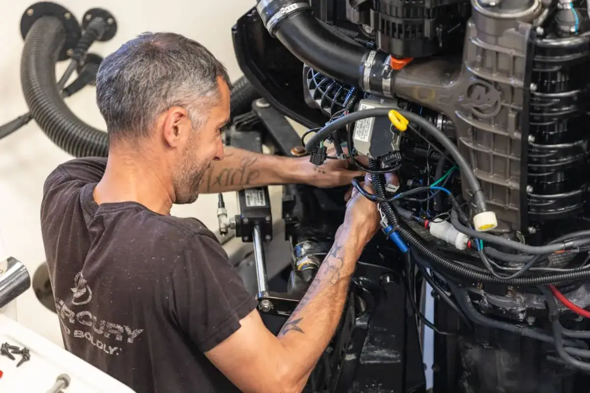 Mécanicien travaillant sur un moteur inboard. Obtenez le meilleur prix révision moteur inboard pour votre bateau.