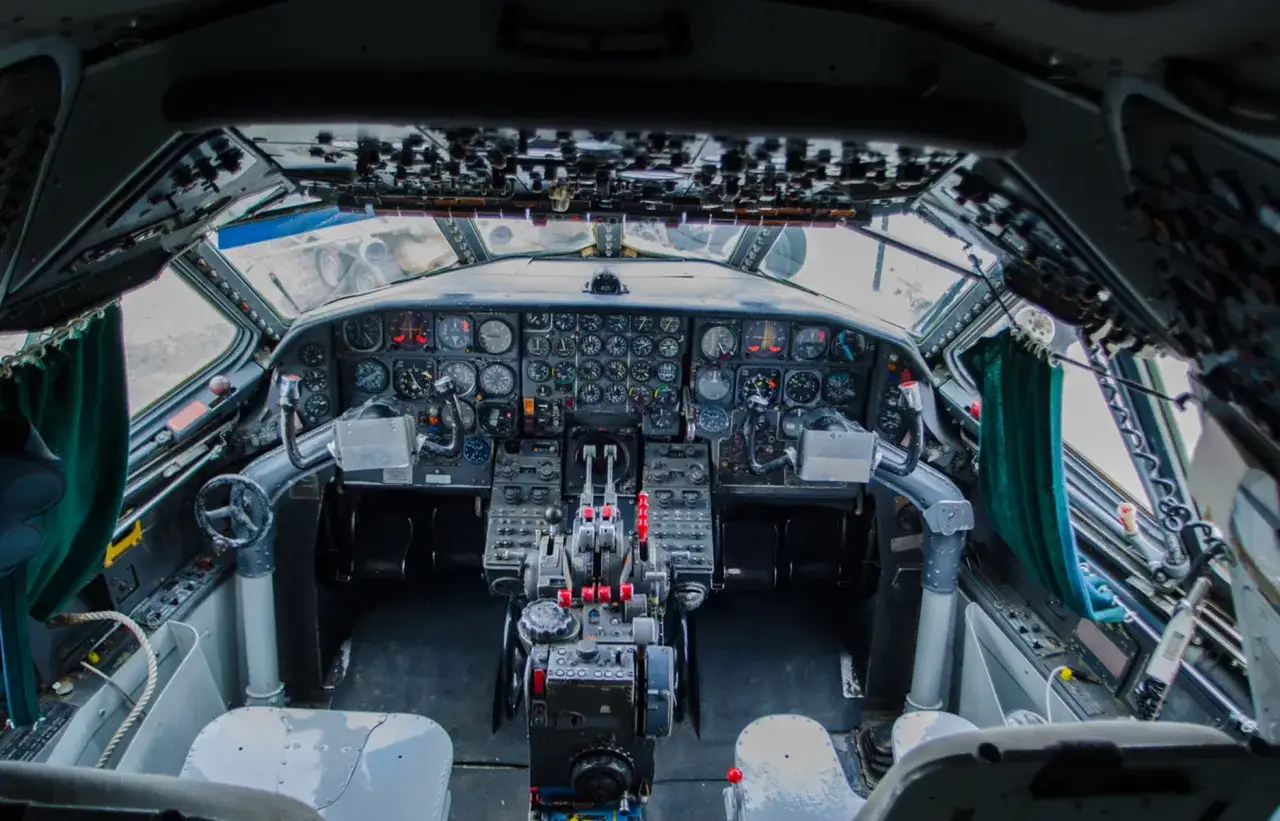 Cockpit d'un avion ancien, plein de cadrans et de leviers. On dirait le tableau de bord d'un dériveur Caravelle polyester prêt pour le décollage.