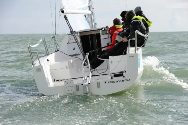 Équipage sur un voilier polonais transportable naviguant sur une mer agitée.